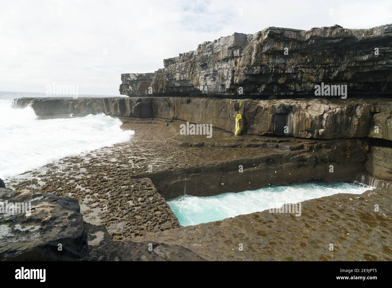 Acantilados y el famoso Worm Hole, una piscina natural en Inishmore, Islas Aran, Irlanda Foto de stock