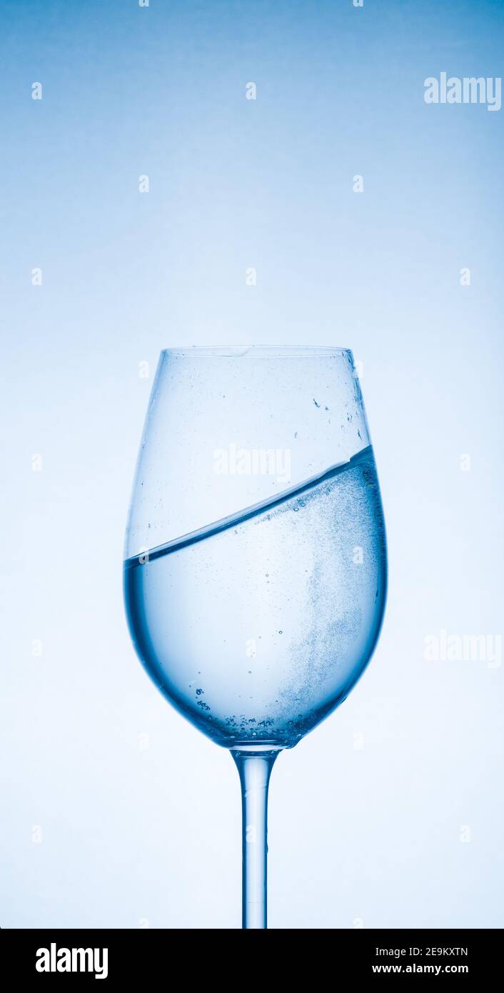 Agua clara en un vaso, delicioso manantial transparente con un chapoteo en el cristal Foto de stock