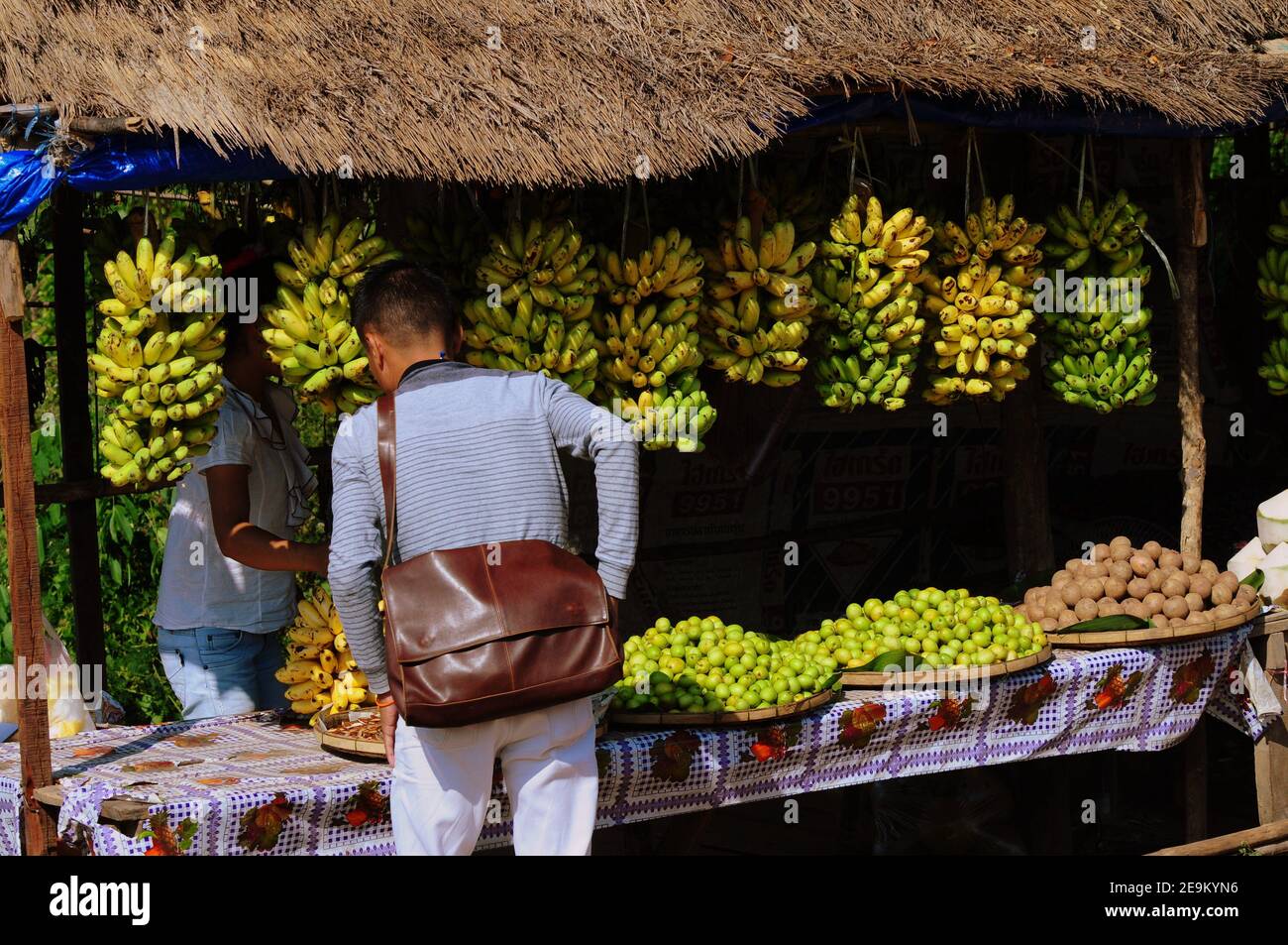 El turista compra frutas y verduras frescas en un puesto de mercado en Vieng Vang, Laos Foto de stock