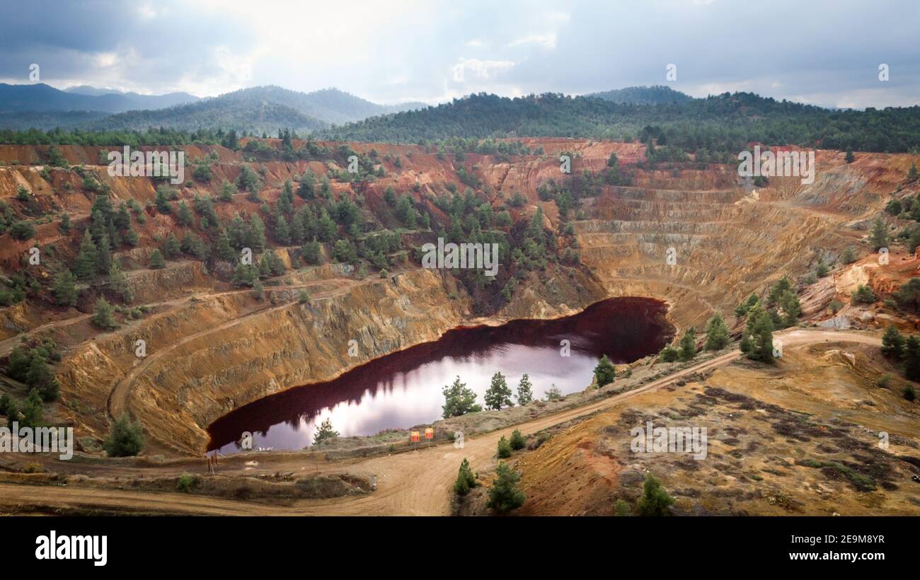 Lago rojo en el cráter de la abandonada mina de cobre a cielo abierto Kokkinopezoula cerca de Mitsero, Chipre. Su color extraño deriva de los altos niveles de ácido y fuerte MET Foto de stock