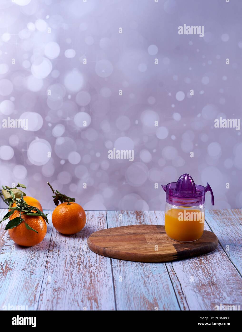 Exprimidor de cristal, zumo de naranja, mesa de madera naranjas enteras con  hojas verdes de fondo brillante Fotografía de stock - Alamy