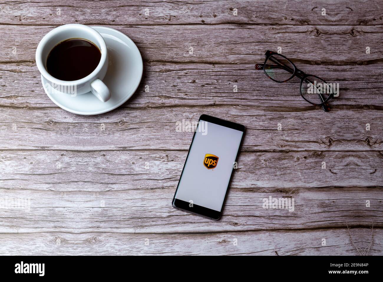 Un teléfono móvil o celular colocado sobre una madera Mesa o mesa con la  aplicación de entrega UPS abierta Fotografía de stock - Alamy