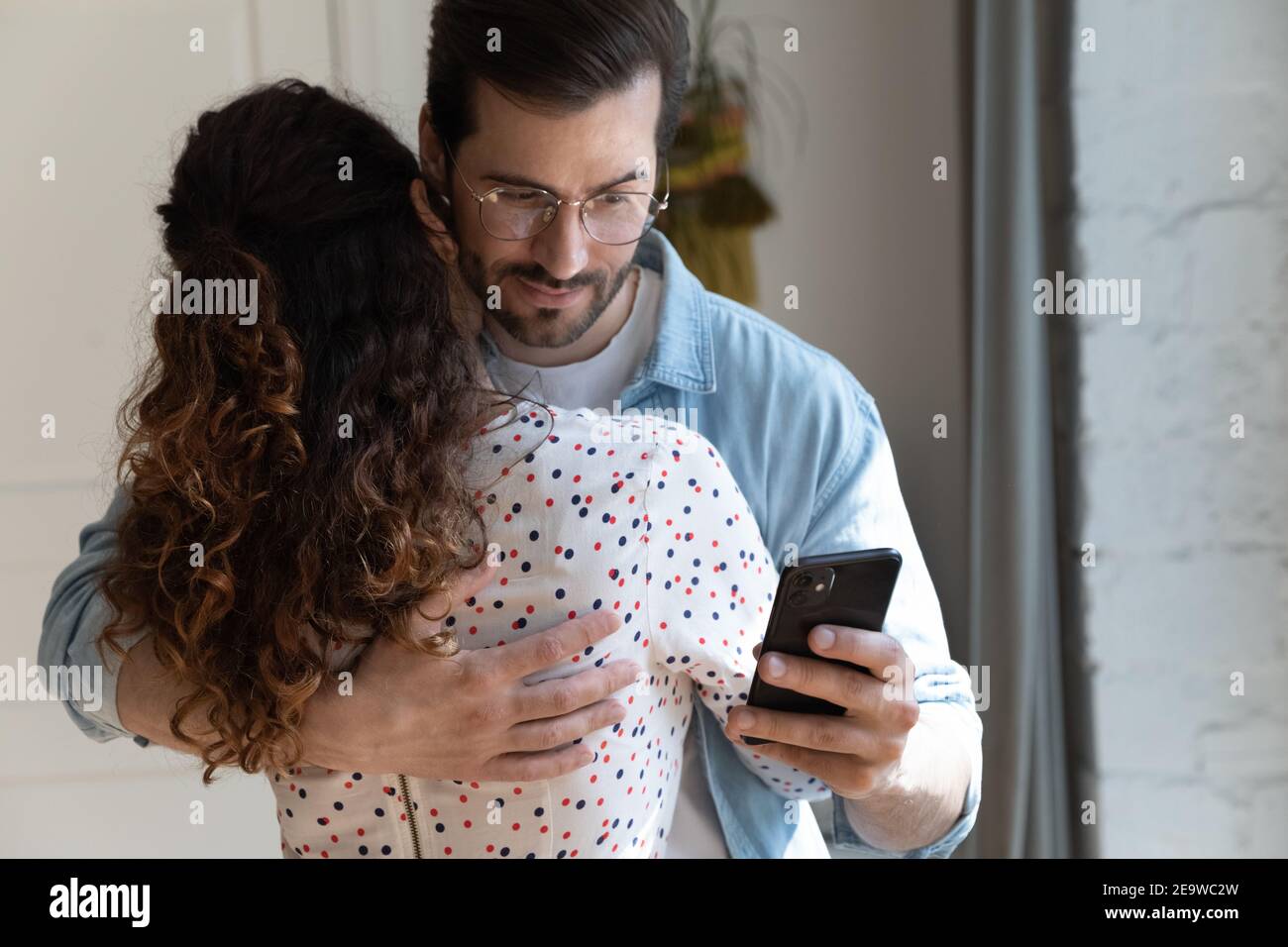 El marido injusto simula el amor con la esposa mientras lee los mensajes de la amante Foto de stock