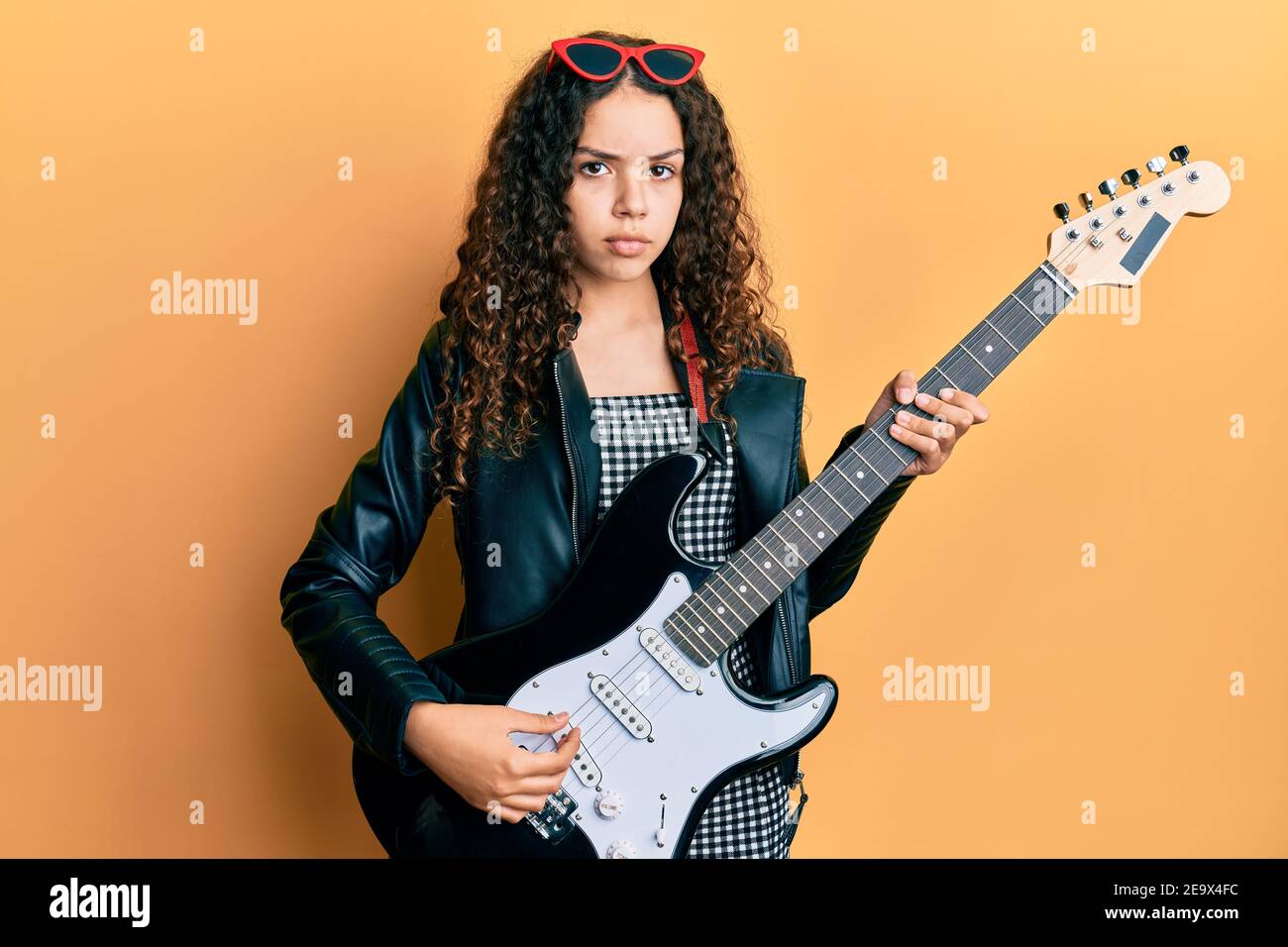Adolescente niña hispana tocando guitarra eléctrica escéptica y nerviosa,  desgustada por problemas. Persona negativa Fotografía de stock - Alamy