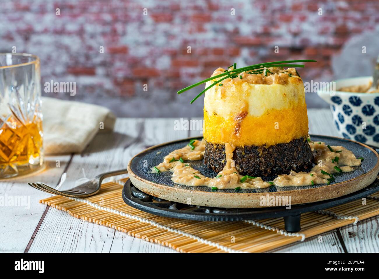 Haggis, neeps y tatties pila (haggis con nabos y patatas) con salsa de whisky - plato escocés tradicional para la noche de los burns Foto de stock
