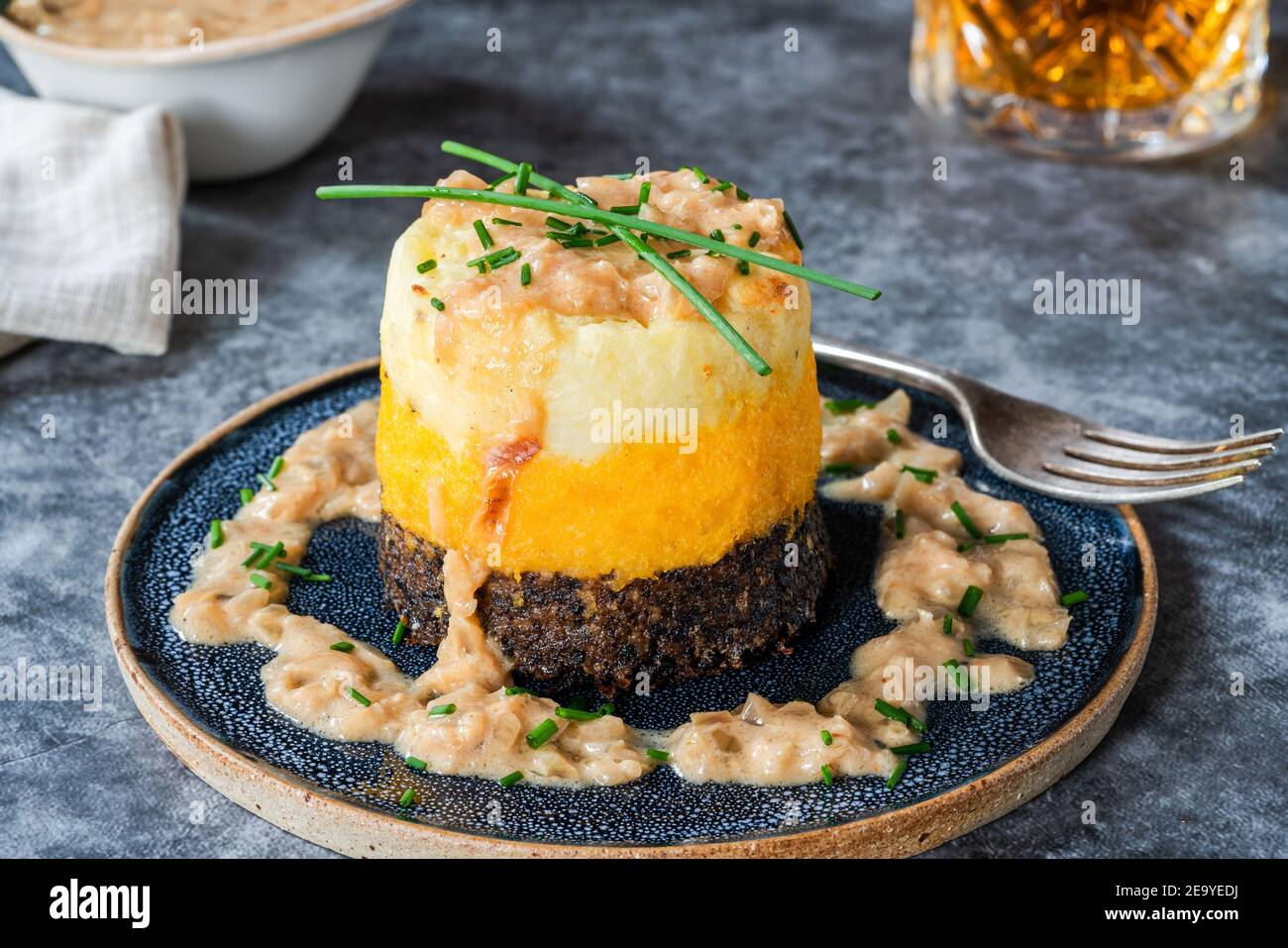 Haggis, neeps y tatties pila (haggis con nabos y patatas) con salsa de whisky - plato escocés tradicional para la noche de los burns Foto de stock