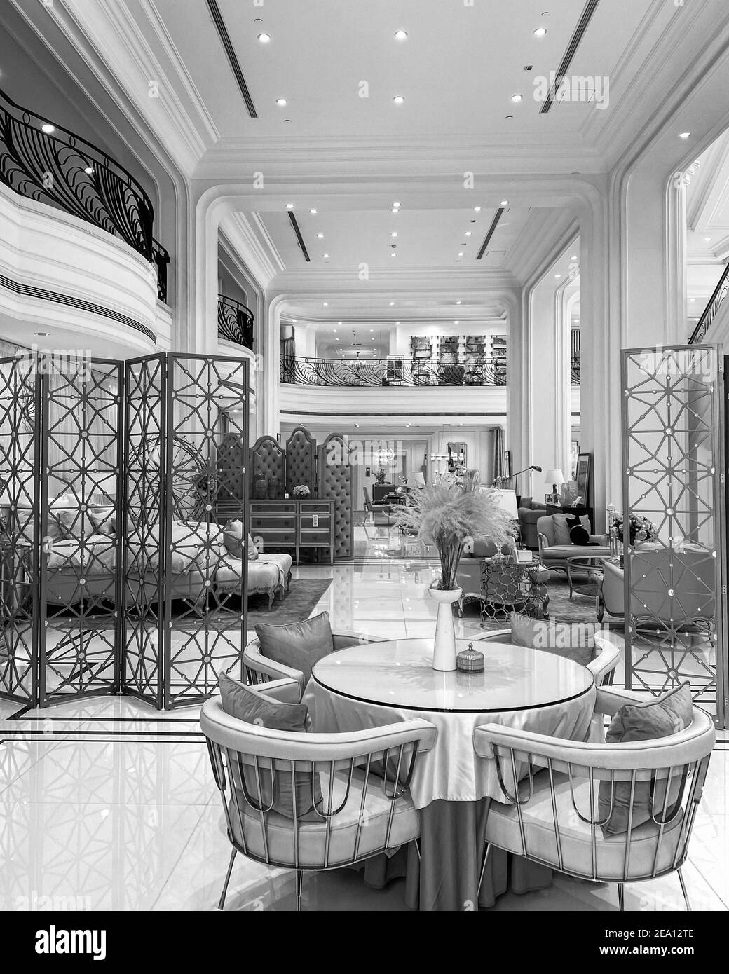 Increíble diseño interior de casa de té restaurante dúplex o elegante tienda de muebles. Hermosa mesa redonda en frente con una bonita decoración rosa. Foto de stock