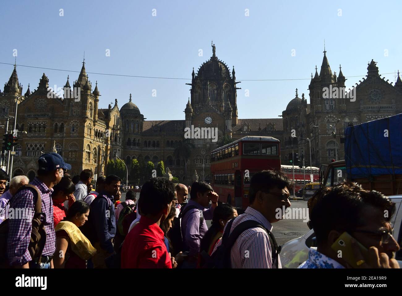 Mumbai, India - Enero de 2017: Multitud de personas cruzando la calle en el fondo de la estación de tren Chhatrapati Shivaji Terminus (Victoria Terminus) Foto de stock