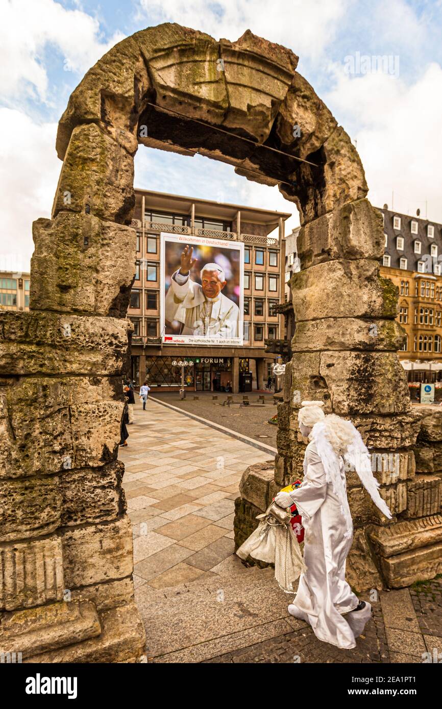 Actor disfrazado de ángel en la Catedral de Colonia frente al cartel del Papa Benedicto, Alemania Foto de stock