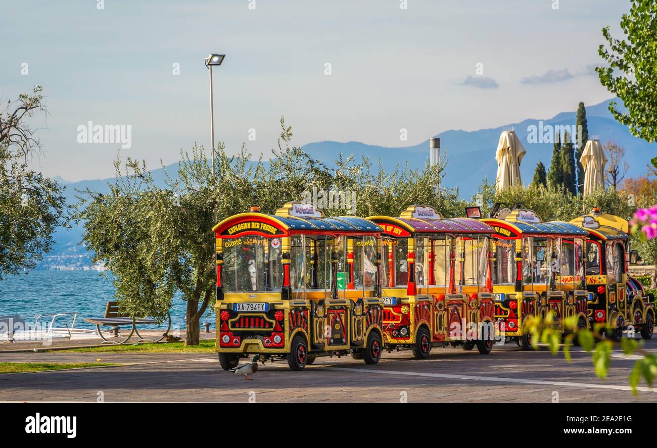 El pequeño tren de la Ciudad de Bardolno. Este pequeño tren lleno de color lleva a los turistas en un recorrido turístico por Bardolino, uno de los atractivos locales Foto de stock