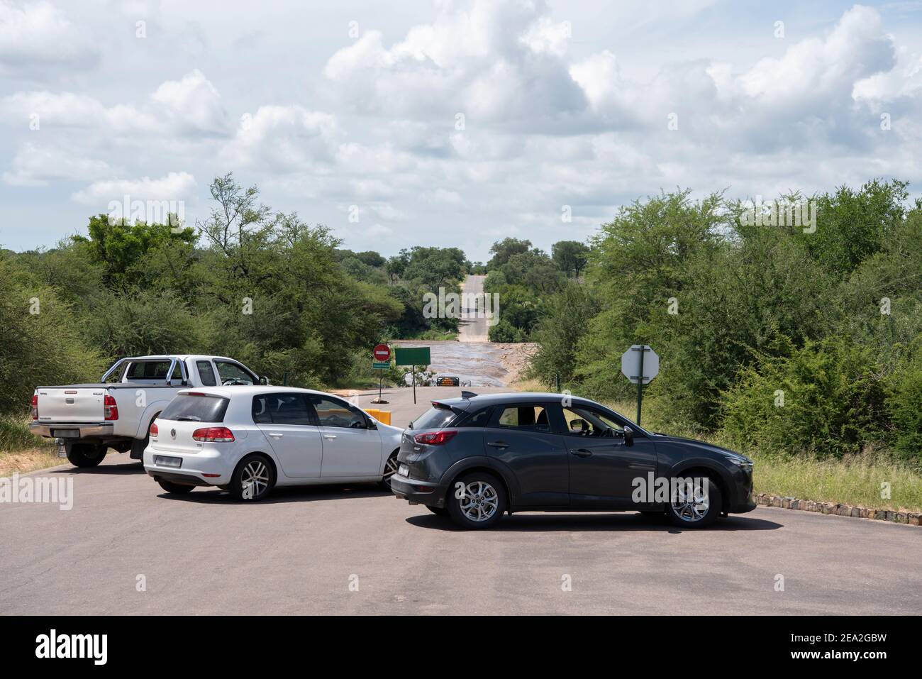 Los vehículos tienen que hacer un desvío debido a una carretera Estar cerrado en el Parque Kruger porque un puente era bajo el agua Foto de stock