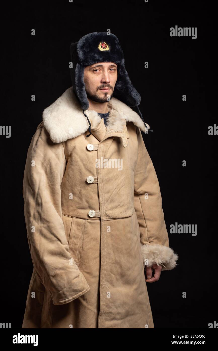 Retrato de un hombre de apariencia caucásica en un soviético sombrero de  piel de oficial y abrigo de piel de oveja del ejército Fotografía de stock  - Alamy