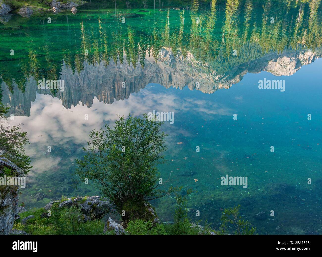 El bosque y las montañas se reflejan en la esmeralda lago Foto de stock