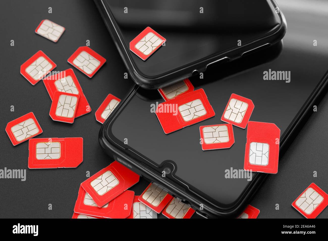 Dos teléfonos celulares y muchas tarjetas SIM. El concepto de fraude, engaño, marcado masivo. Foto de stock