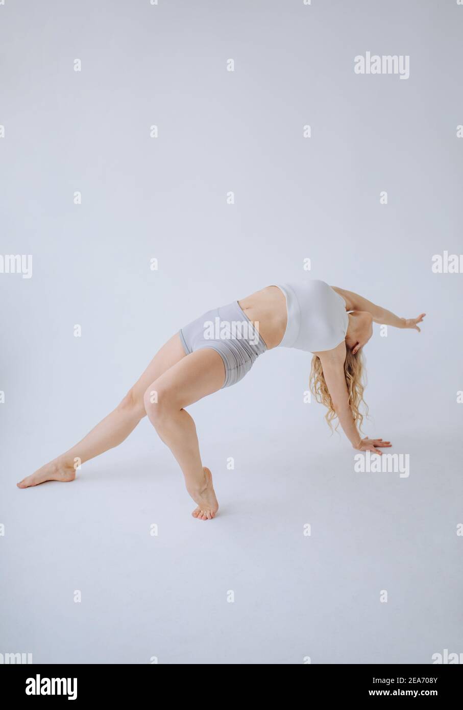 Gimnasta femenina haciendo una curva en la espalda en un estudio Foto de stock