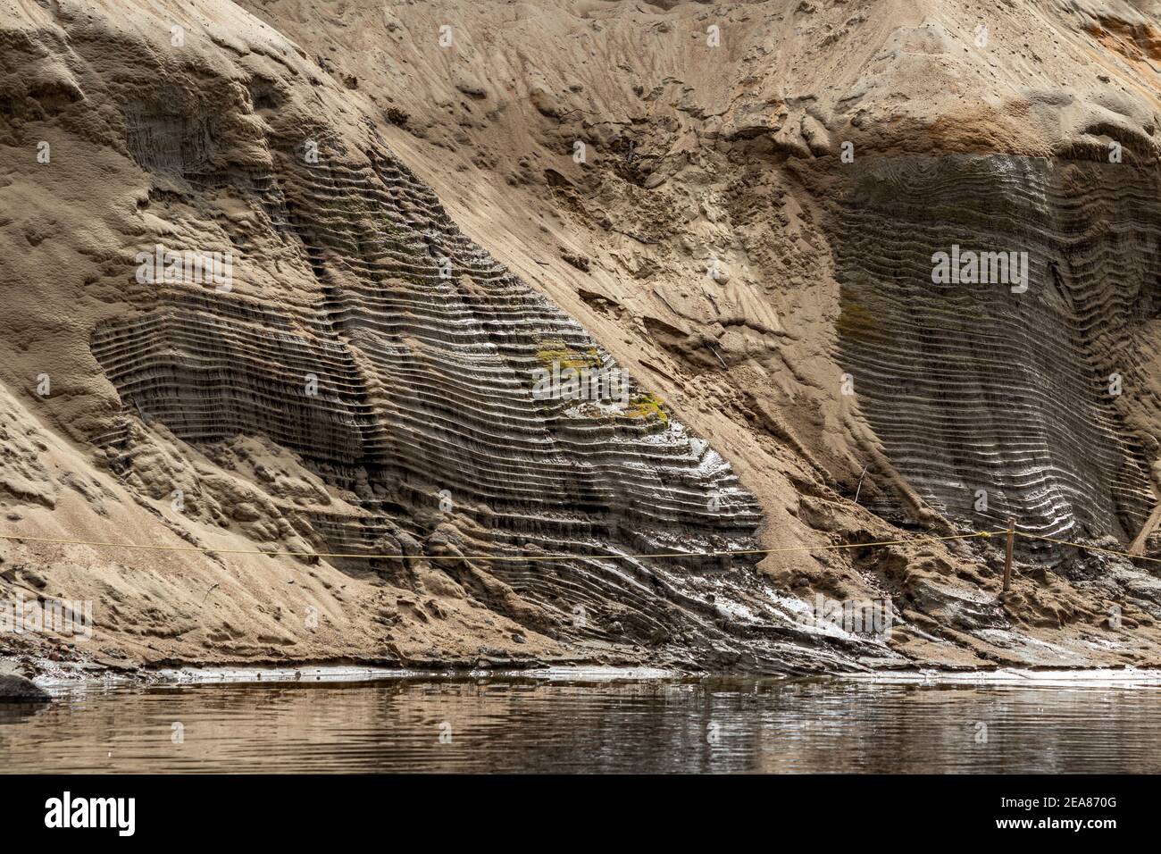A lo largo del río Devil's en el Parque Nacional Mont Tremblant, el río ha erosionado la orilla para formar pequeños escalones. La arena de las horas extraordinarias ha llegado a cubrir la mayor parte de ella Foto de stock