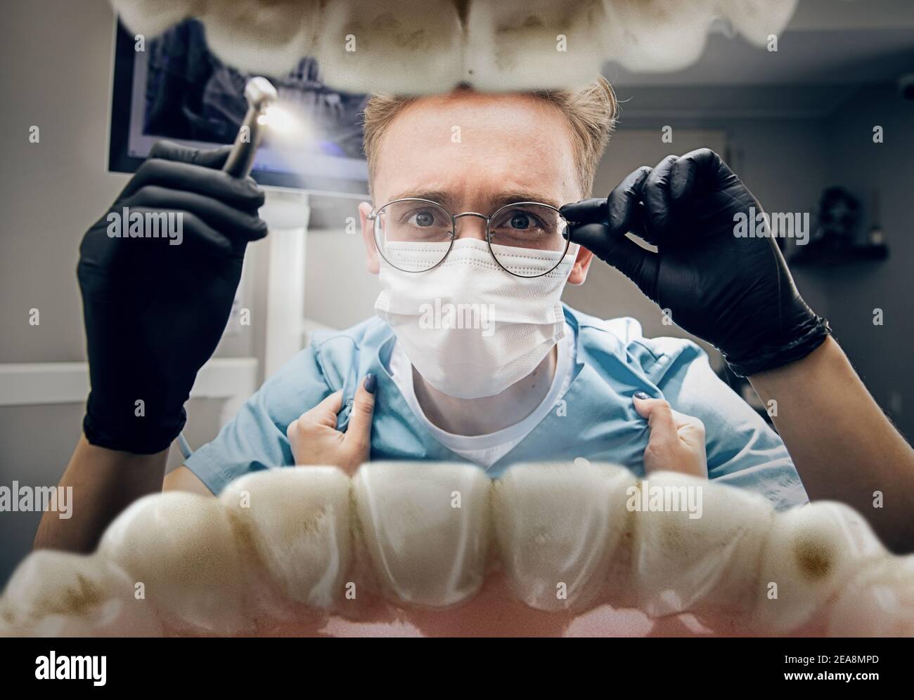 Las manos femeninas se agarran de la bata. Doctor mirando en la boca, revisando, examinando los dientes. Uso de herramientas y equipos. Salud y medicina, estomatología, sentimientos de paciente. Mire desde el interior de los dientes. Foto de stock