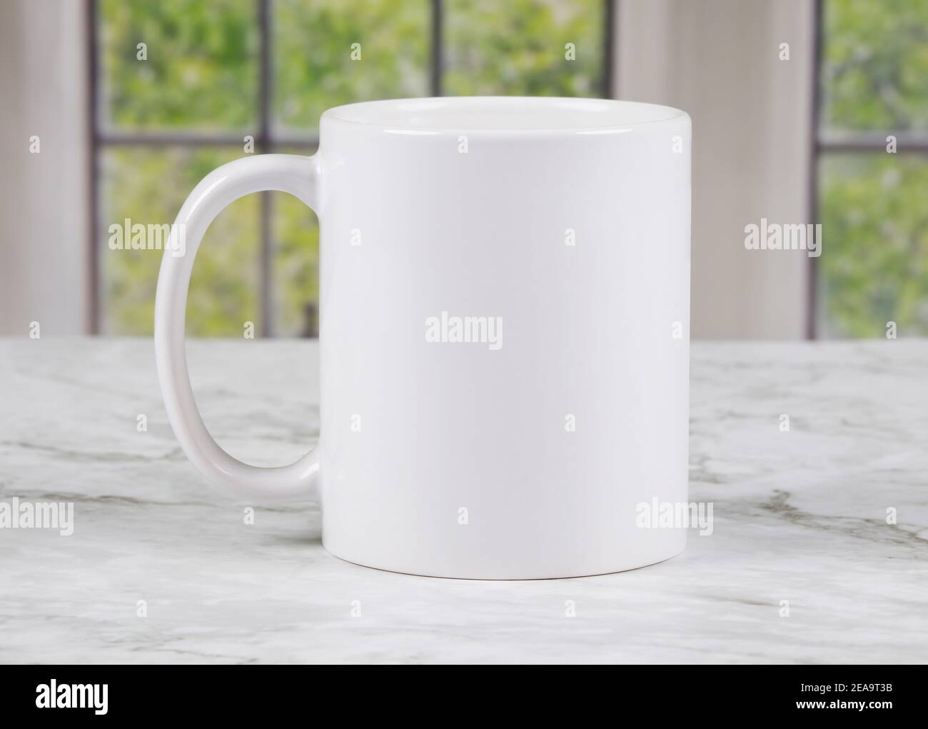 Taza de café blanca con espacio para copiar en la superficie de la cocina de mármol con ventanas en el fondo Foto de stock