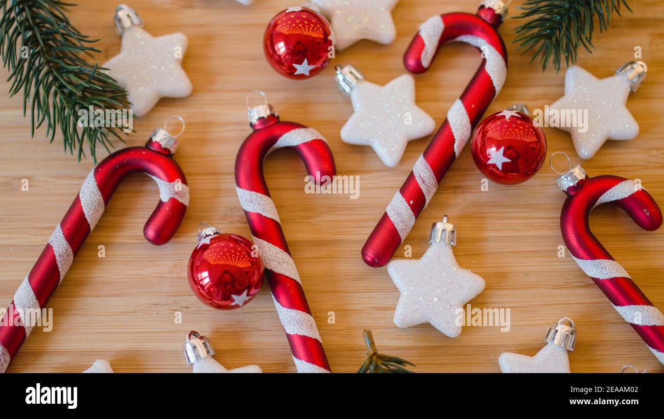 Colgantes de Navidad, bastones de caramelo y estrellas y bolas de árbol de  Navidad en rojo y blanco, ramas de abeto, primer plano Fotografía de stock  - Alamy