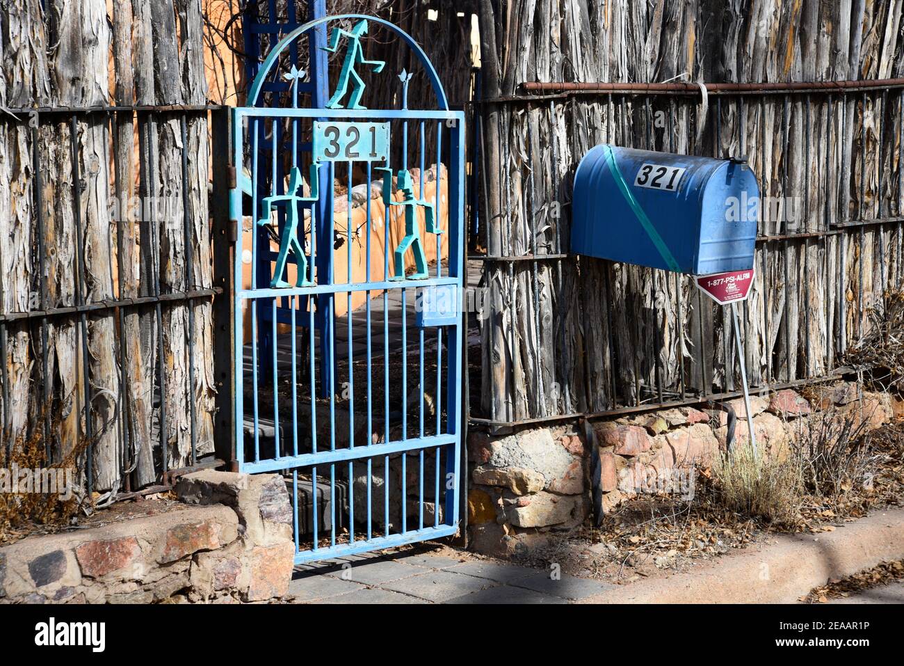 Una casa en Santa Fe, Nuevo México, con una valla de coyote y puerta de  hierro hecha a medida y buzón, ambos pintados en azul a juego Fotografía de  stock - Alamy
