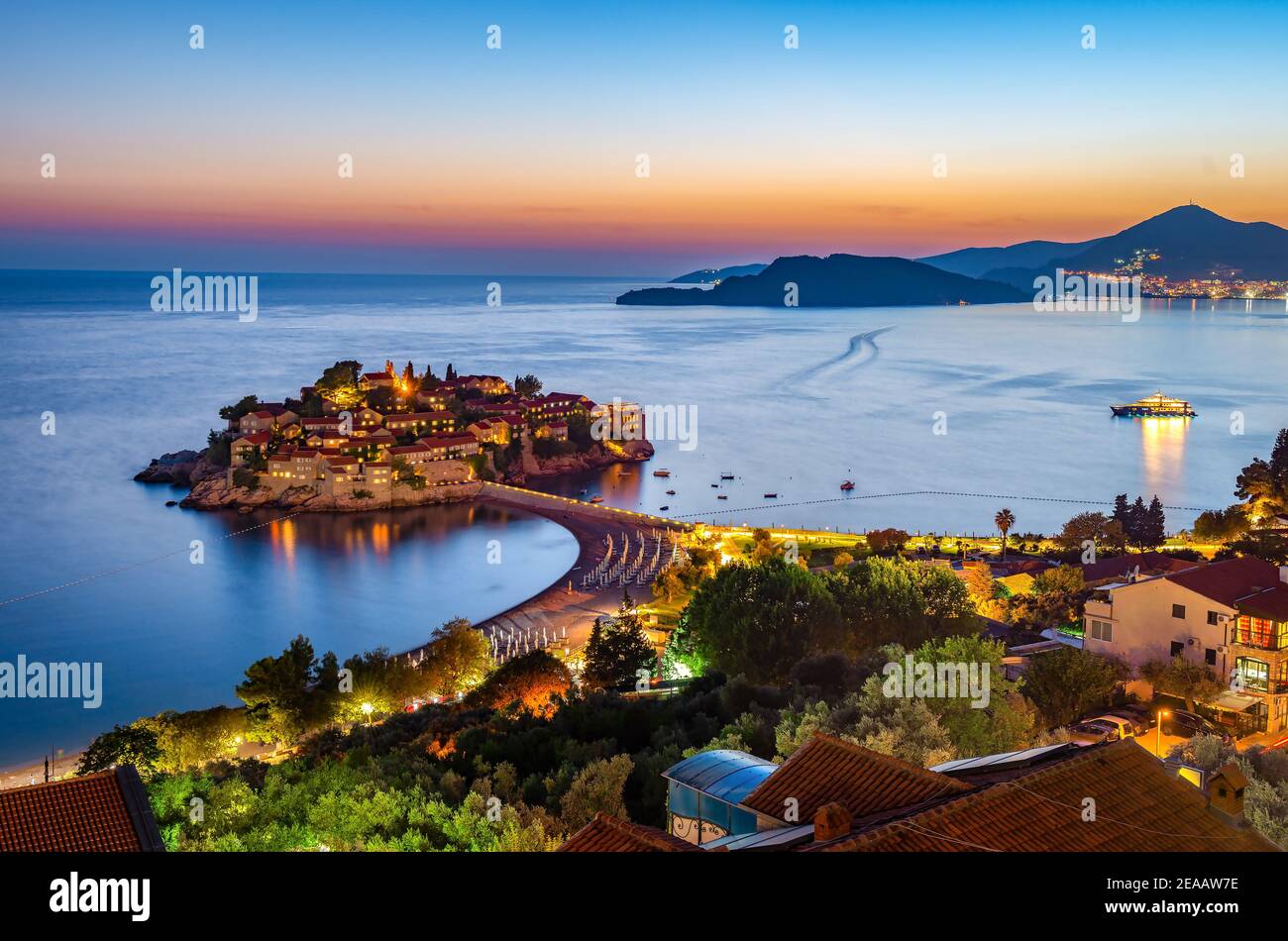 Isla Sveti Stefan en Montenegro, puesta de sol en la costa. Destino de viaje popular Foto de stock