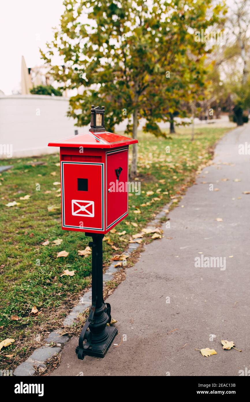 Buzón de metal rojo en la calle. Fondo borroso Foto de stock