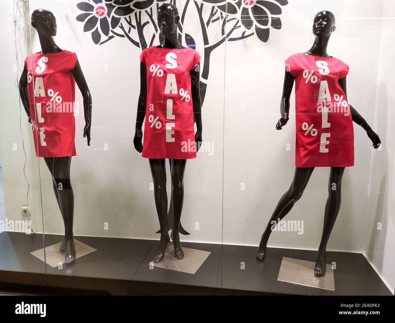 Tres maniquíes negros en vestidos rojos con la inscripción Venta en la  ventana de la tienda. Comprar y vender ropa para mujeres Fotografía de  stock - Alamy