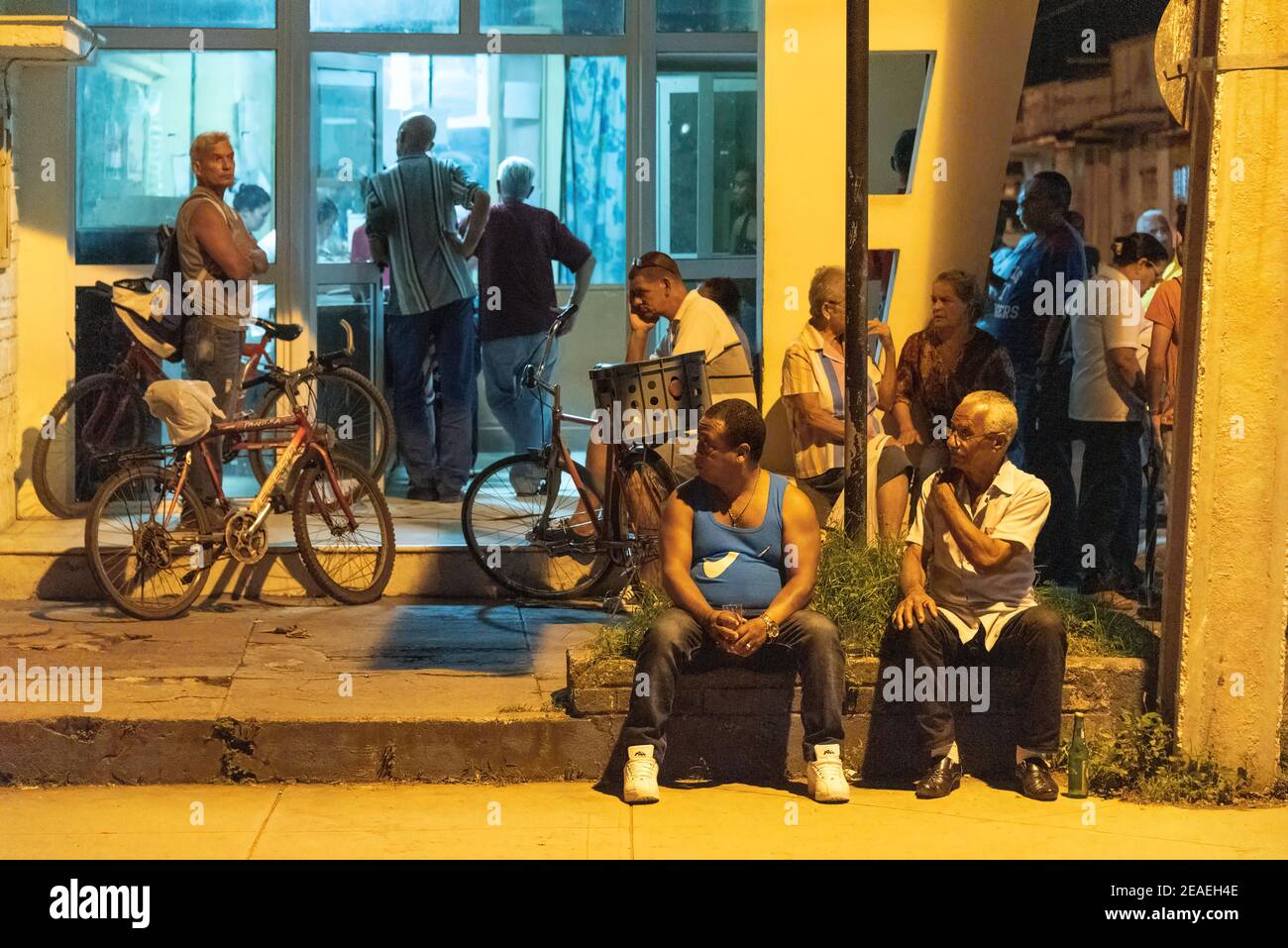 Personas que se alinean en una farmacia por la noche, Santa Clara, Cuba Foto de stock