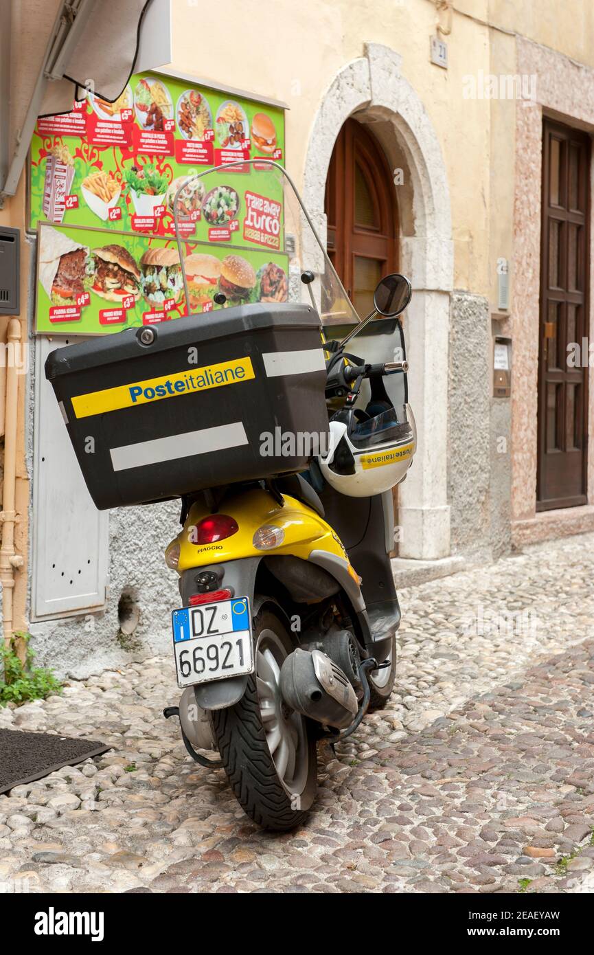 Piaggio Liberty scooter en el Poste Italiane S.p.A. Livery estacionado fuera de una tienda en Malcesine, Lago de Garda, Italia. Foto de stock