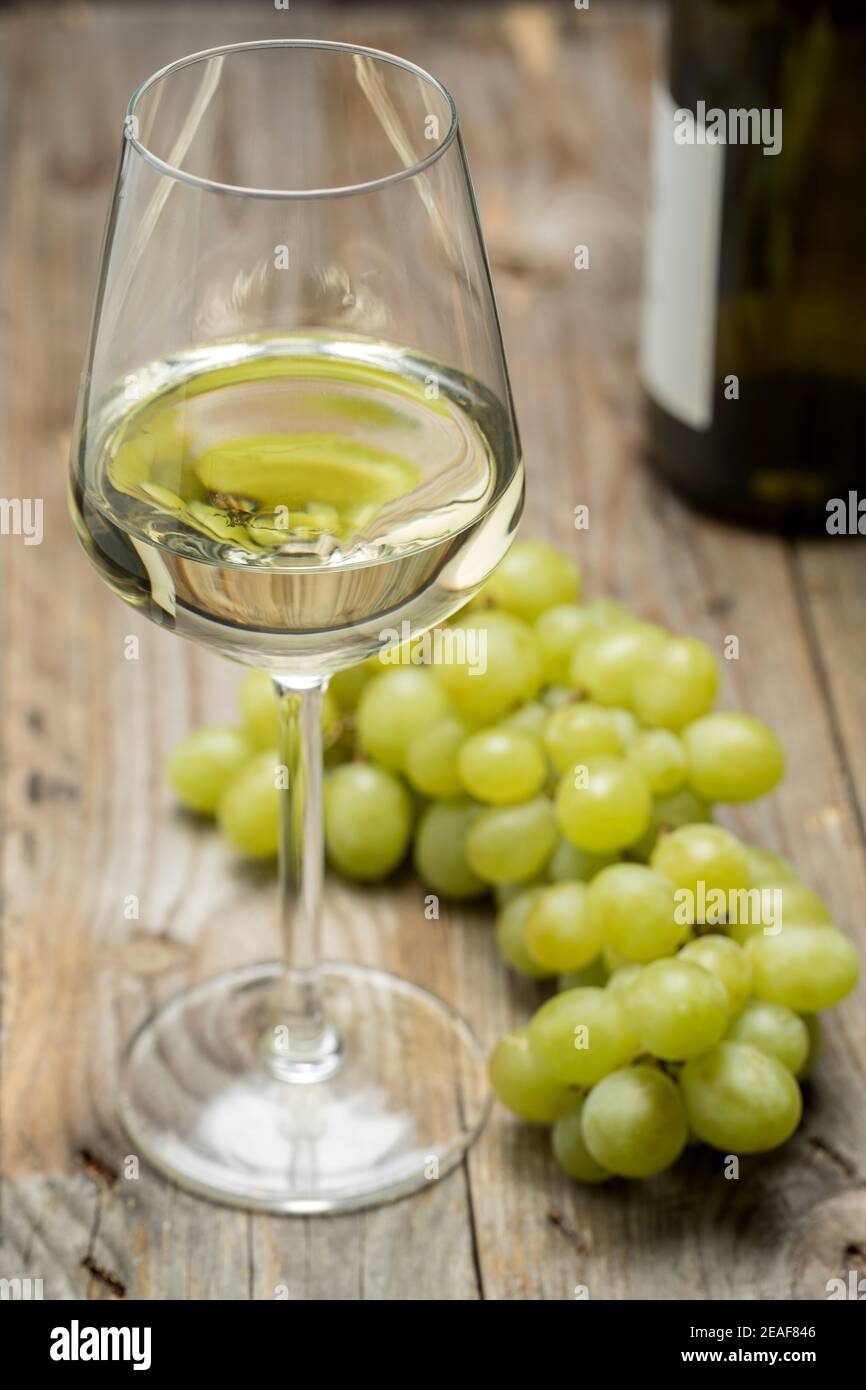 Copa de vino con uvas sobre un fondo de madera. Foto de stock