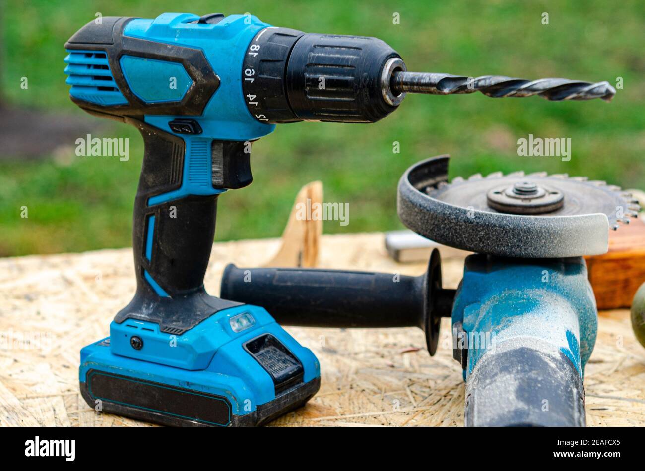 Un taladro de batería azul está sobre una mesa de madera en el jardín.  Electtroinstruye. Reparar. Construcción Fotografía de stock - Alamy