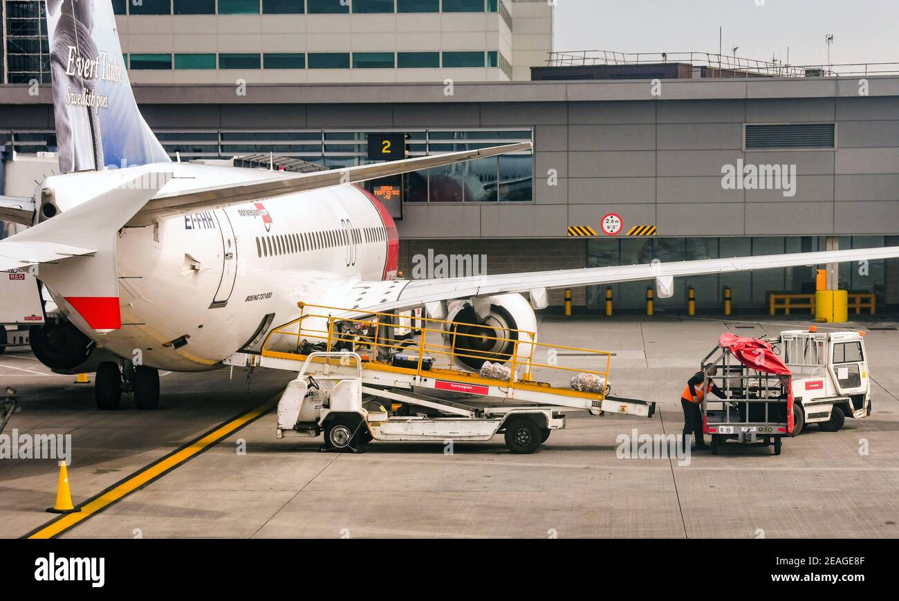 AEROPUERTO GATWICK DE LONDRES, INGLATERRA - ABRIL 2019: Vehículo con cinta  transportadora de equipaje descargando maletas de la bodega de carga de un  Boeing 737 de Norwegian Air Fotografía de stock - Alamy