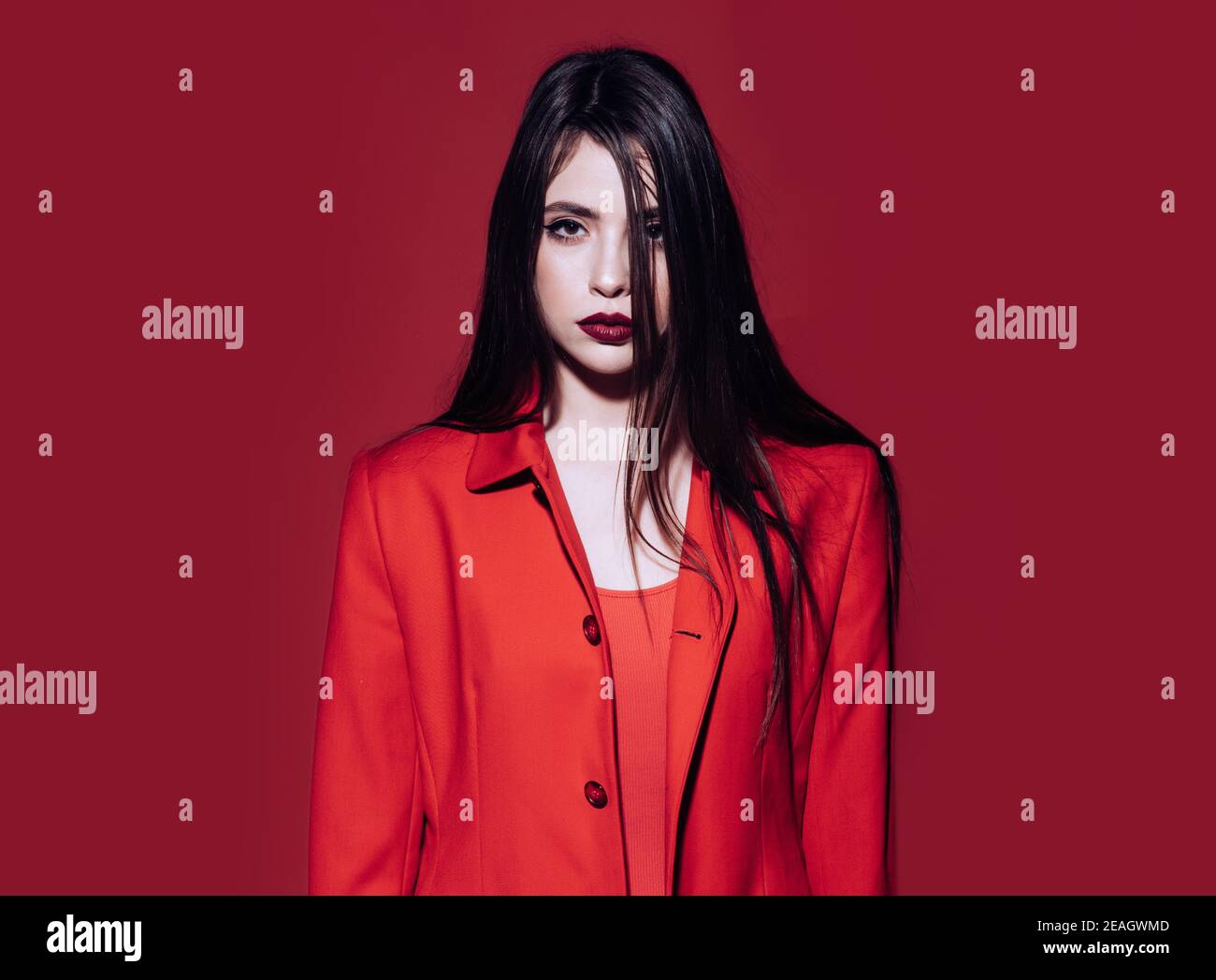 Señora en rojo. Mujer joven posando en conjunto rojo total. Concepto de  moda. Chica en rojo chaqueta formal, fondo rojo. Dama con labios oscuros  mirando la cámara Fotografía de stock - Alamy