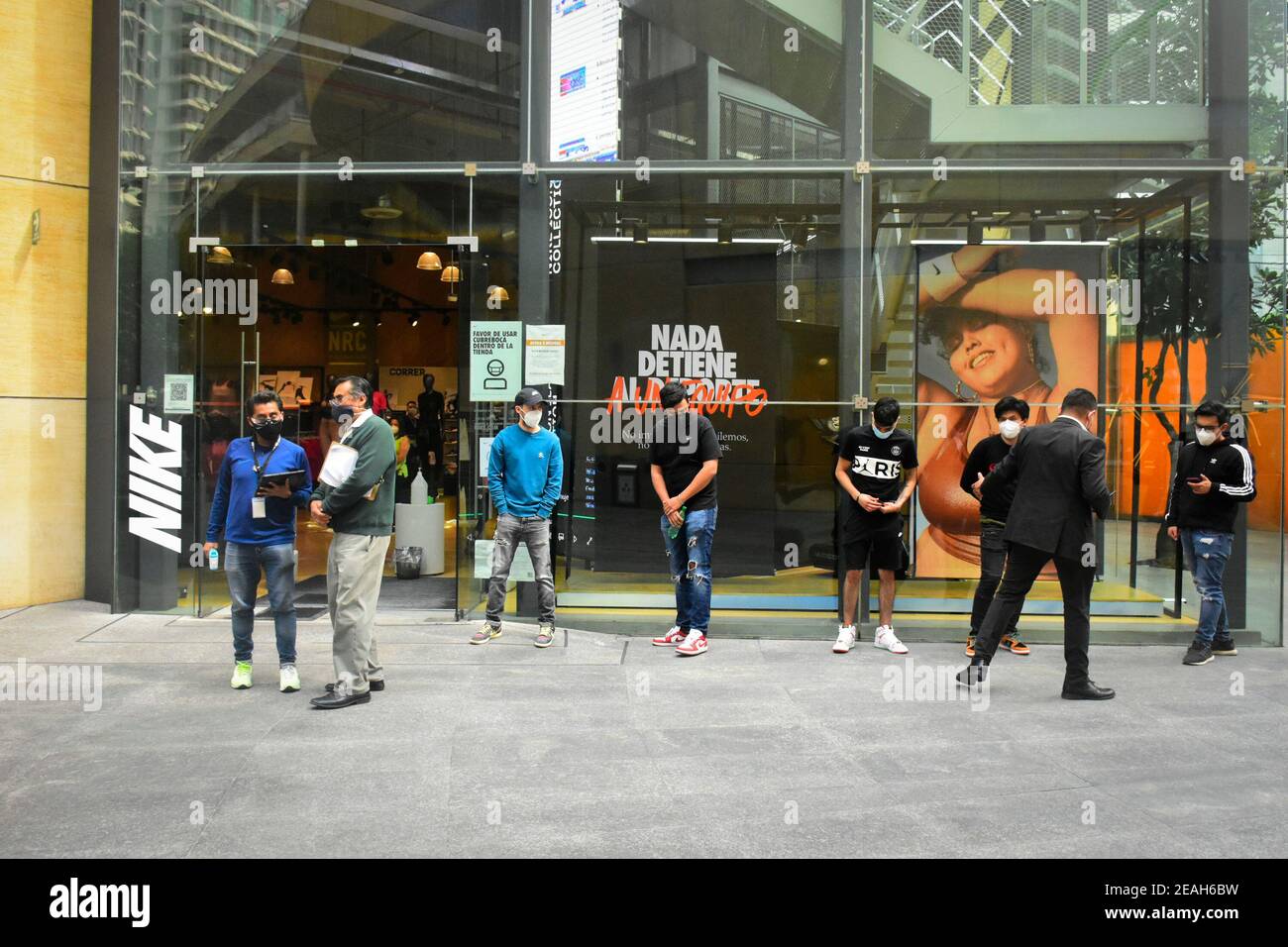 Las personas que usan máscaras faciales se para entrar en una tienda Nike en Antara Fashion Hall.como parte del programa "Activar riesgo", Malls y grandes almacenes se abrieron este