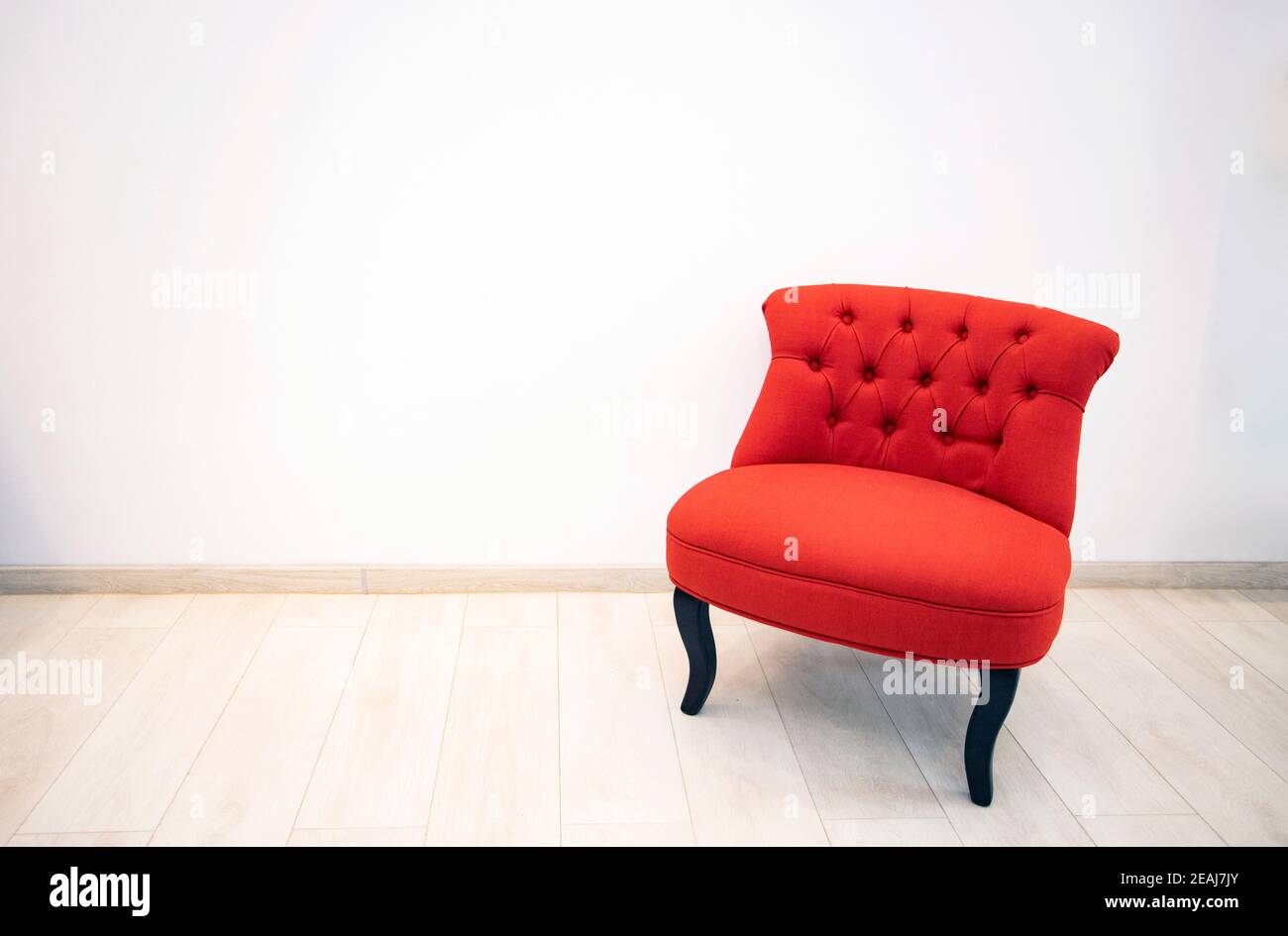 Antiguo sillón rojo en la habitación blanca Foto de stock