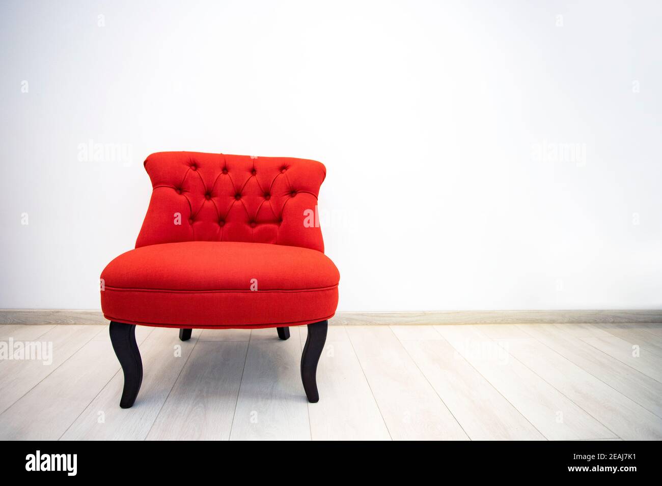 Antiguo sillón rojo en la habitación blanca Foto de stock