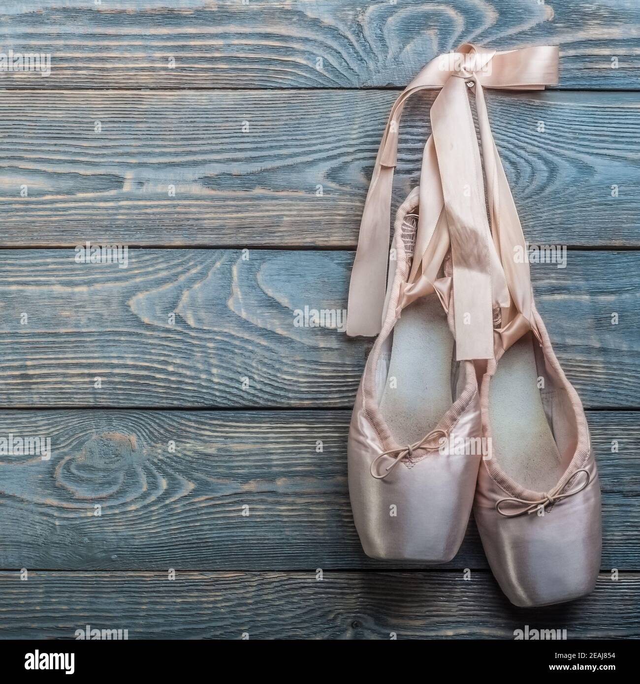 Zapatos de punta ballet zapatos de danza con arco de cintas cuelgan en clavo sobre un fondo de madera Fotografía de stock - Alamy