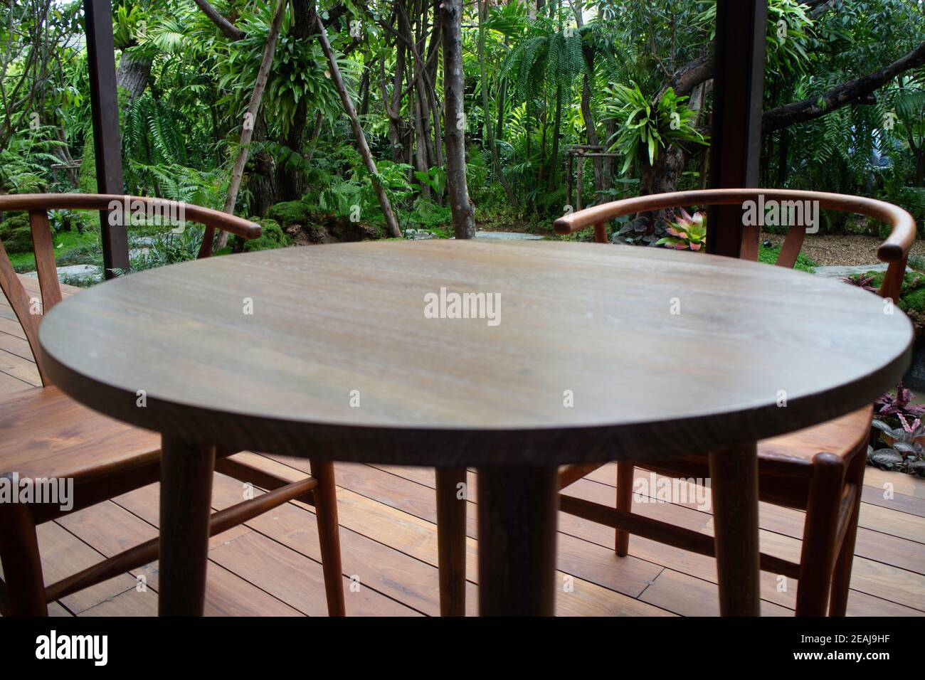 Mesa de madera y sillas en el jardín tropical Foto de stock
