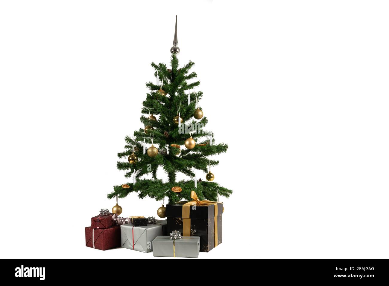 un árbol de navidad decorado con canicas y velas y regalos debajo Foto de stock