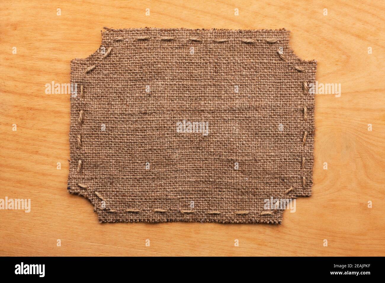 Marco de arpillera, se encuentra sobre un fondo de madera Foto de stock