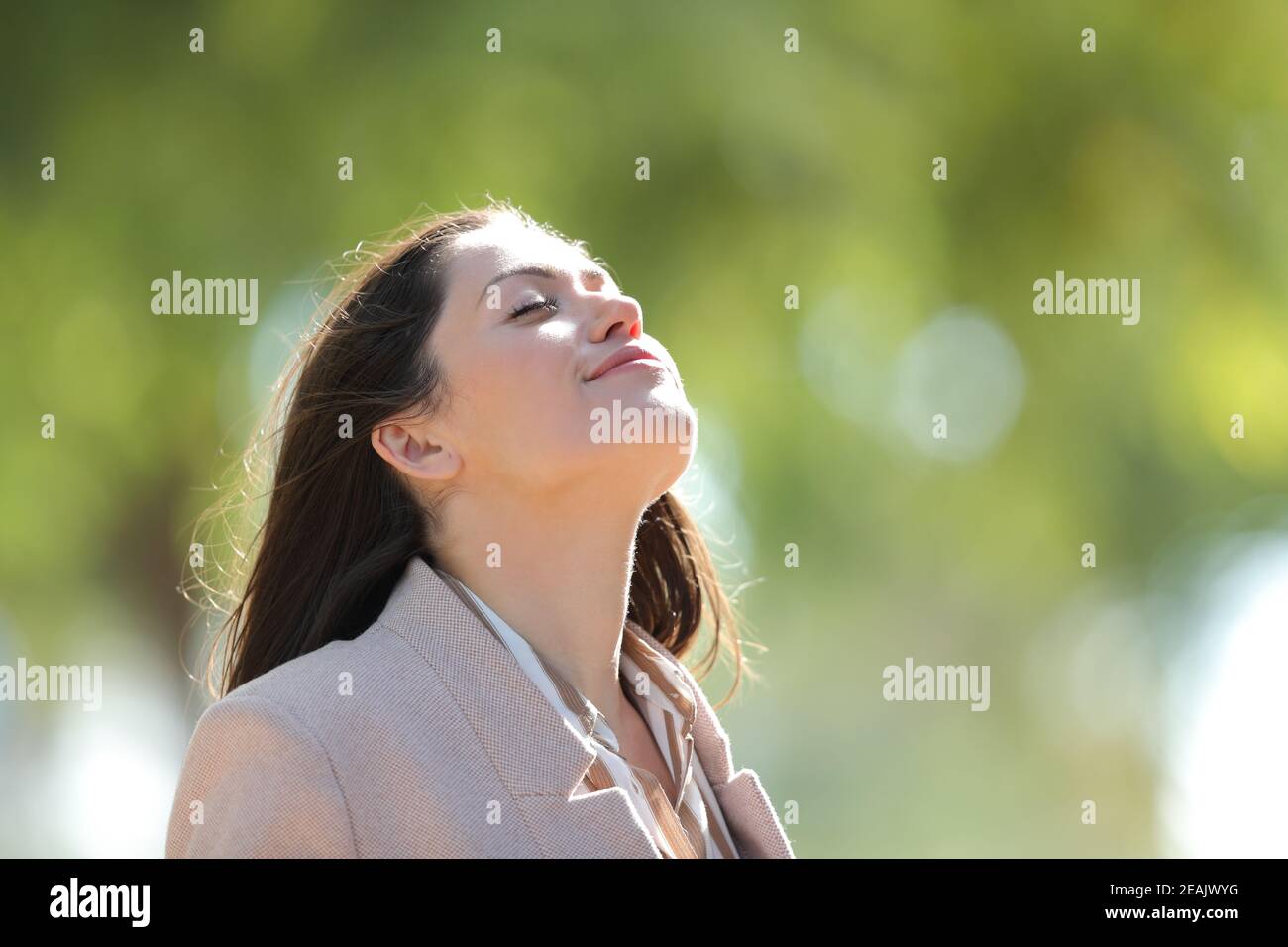 Mujer respirando aire fresco en un parque soleado Foto de stock