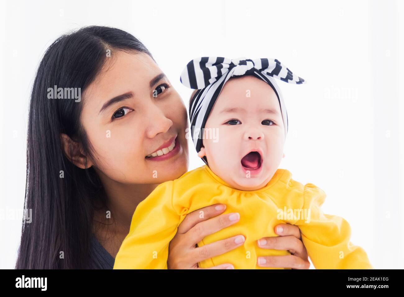 madre jugando y sonriendo con su bebé recién nacido Foto de stock