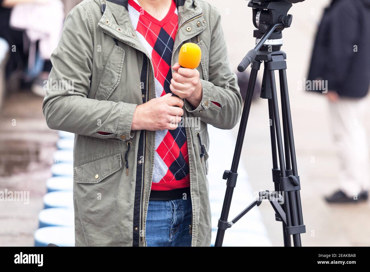 Periodista sosteniendo el micrófono, esperando la conferencia de prensa Foto de stock