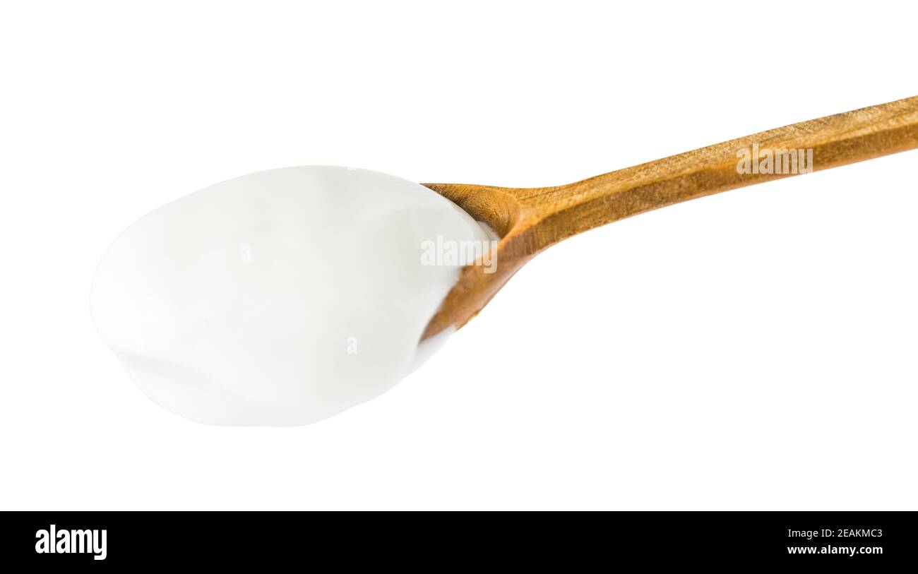 Yogur en cuchara de madera Foto de stock