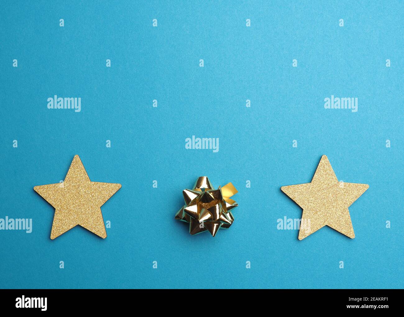 Fondo de Navidad con estrellas doradas y arco en azul Foto de stock