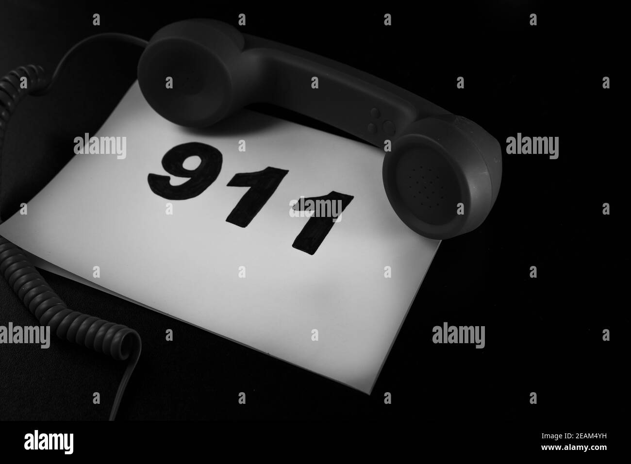Llamada 911 y concepto de llamada de emergencia, texto 911 en papel y teléfono aislado en negro Llamada 911 y concepto de llamada de emergencia, texto 911 en papel y teléfono aislado en negro