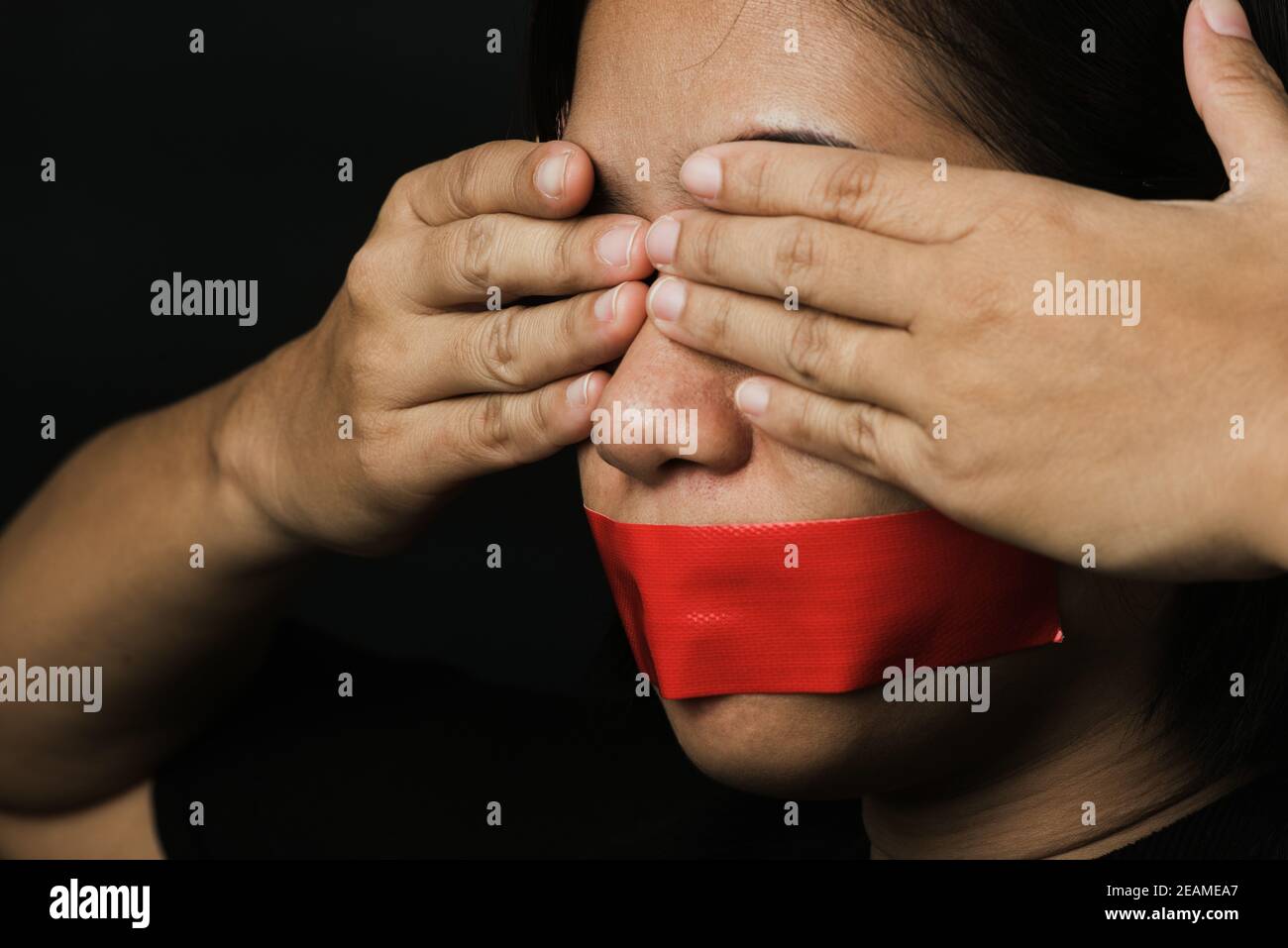 Mujer asiática venda la boca con cinta adhesiva roja Foto de stock