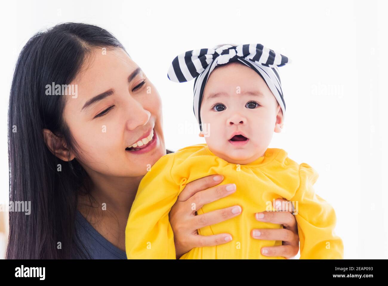 madre jugando y sonriendo con su bebé recién nacido Foto de stock