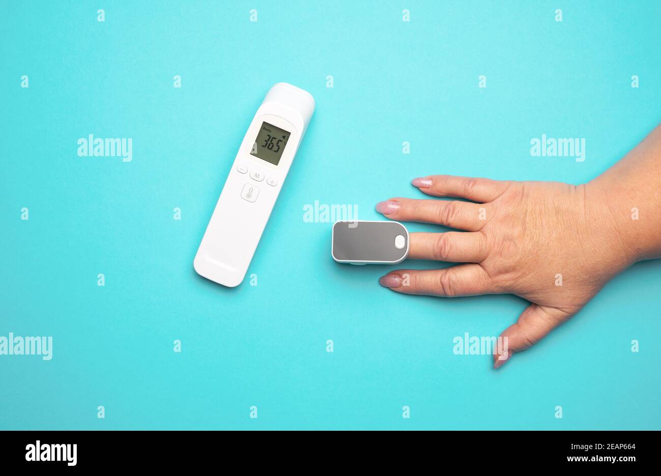 proceso de medir el nivel de oxígeno en la sangre en un dedo, junto a un  termómetro electrónico sin contacto Fotografía de stock - Alamy