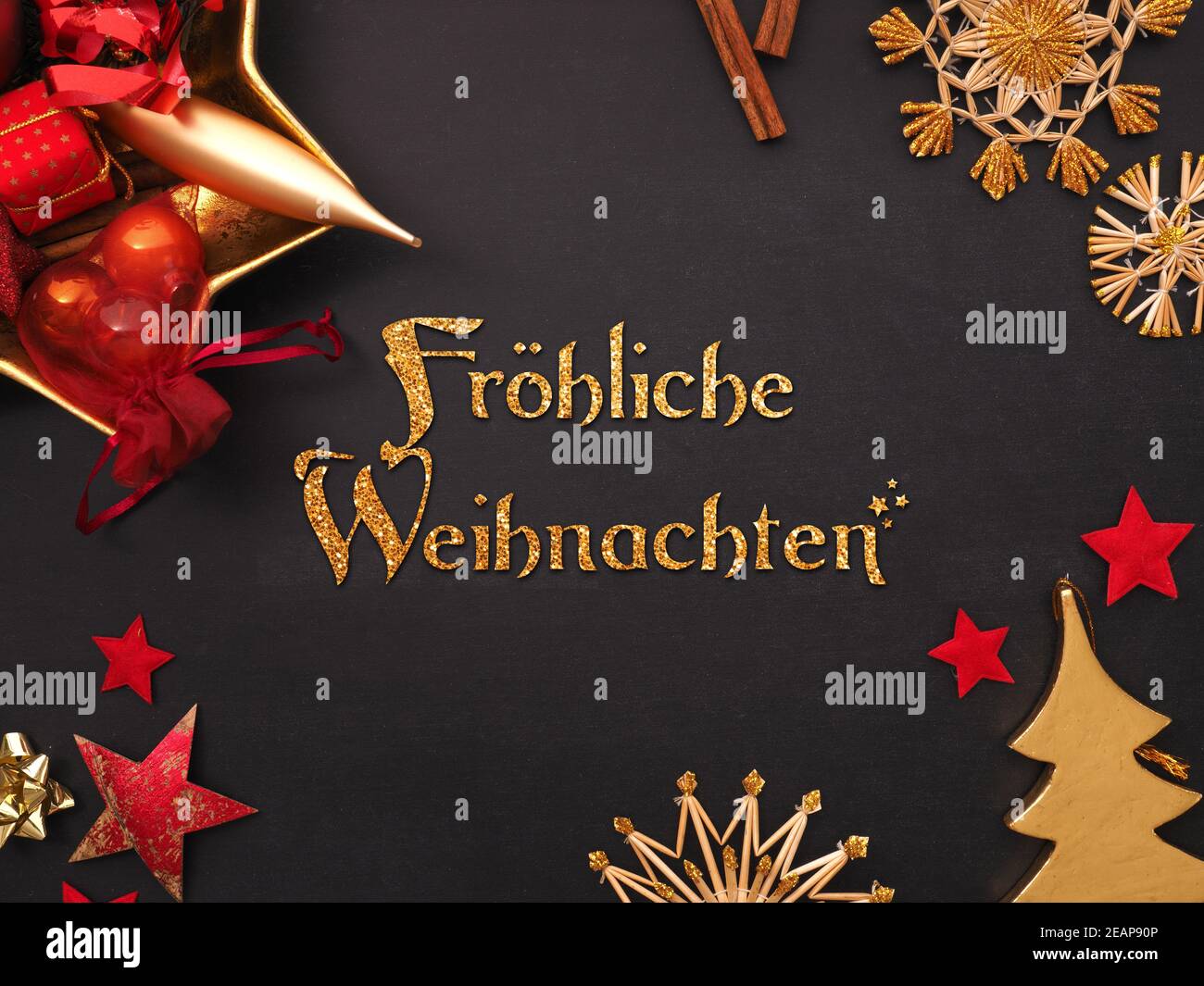 Palabras alemanas Navidad alegre con artículos dorados y rojos de Navidad Foto de stock